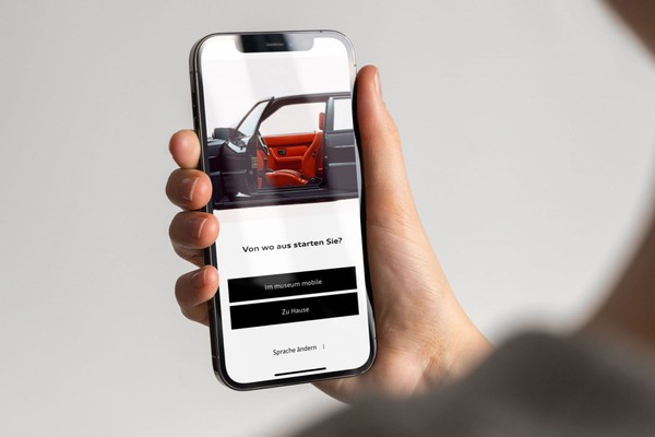Hand hält Smartphone. Geöffnete App: Audi Tradition App